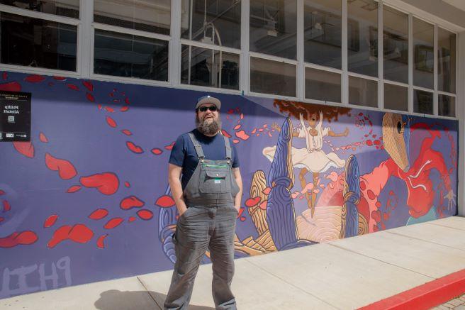 Phillip Alstatt in front of Becoming Mural